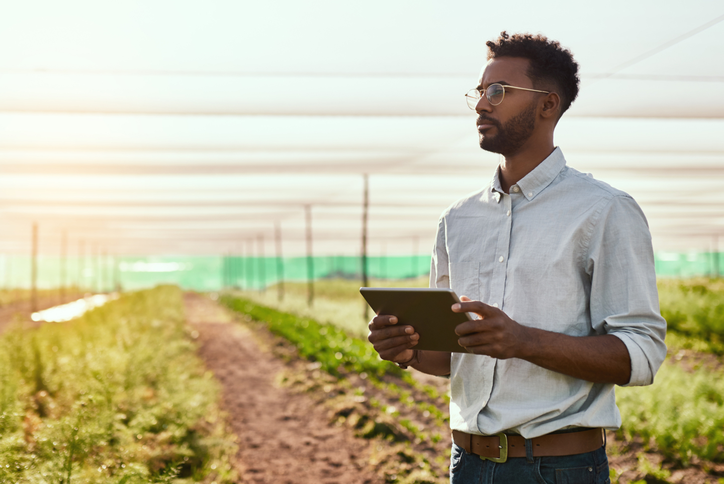 A man with glasses holding a tablet